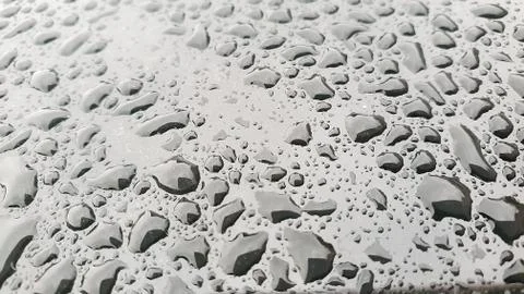 Rain drops on window glasses surface with cloudy background Stock Photos