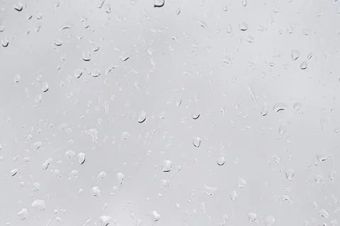 Rain drops on window glasses surface with gray sky background. Natural back.. Stock Photos