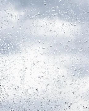 Rain drops on window glasses surface with cloudy sky background . Natural b.. Stock Photos