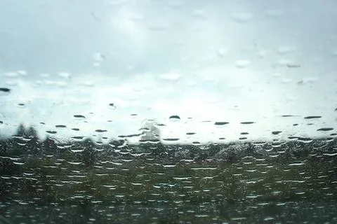 Rain drops on window glasses surface with cloudy background Stock Photos
