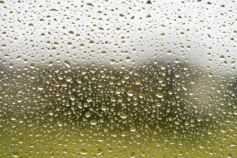 Rain drops on window with grey textured background. Stock Photos