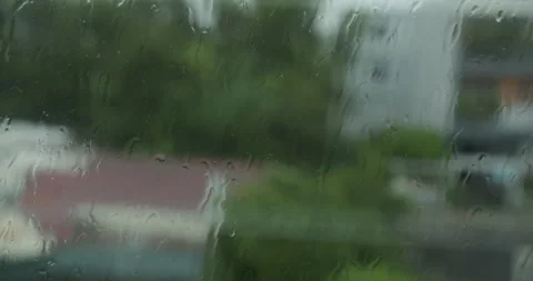 Rain drops window. Large rain drops strike a window pane during a summer shower Stock Footage 263768535