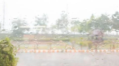 Rain drops on window mirror with green trees, Rainy day window in office Stock Photos