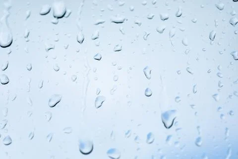 Rain drops on window with out of focus elements Stock Photos