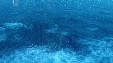 Rain Drops on Window Overlooking Ocean Waves from Inside a Vessel or Cruise Ship Stock Footage 337694448