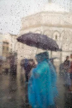 Rain drops on window pane against people at street Stock Photos