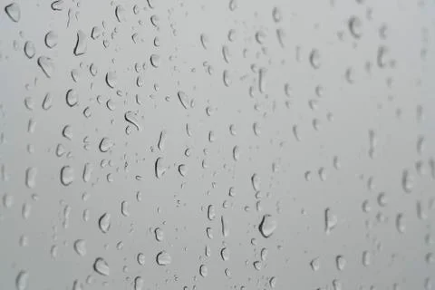 Rain drops on a window pane in a rainy day Stock Photos