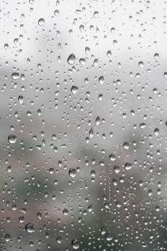 Rain drops on a window pane in a rainy day Stock Photos
