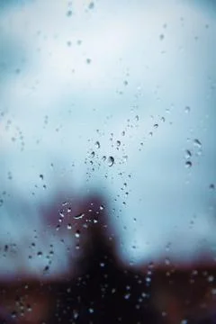 Rain drops on a window surface with blurry shadows Stock Photos