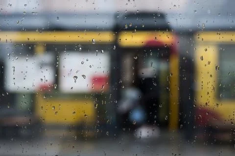 The rain drops of the window at the tramway station in the street Stock Photos