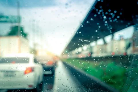 Rain drops on windshield. Car driving on asphalt road on rainy day. Windshiel 库存照片