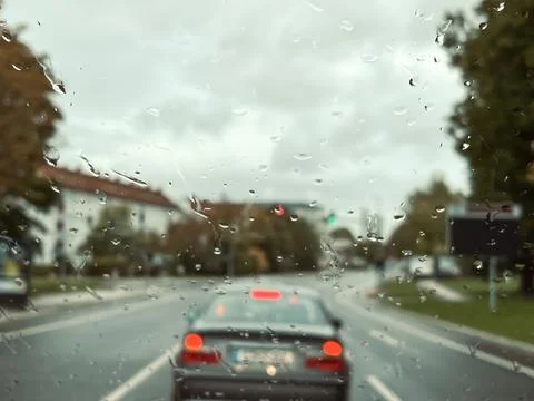 Rain drops on windshield of a car in traffic Stock Photos