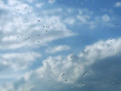 Rain drops on the windshield with cloudy sky background 写真素材
