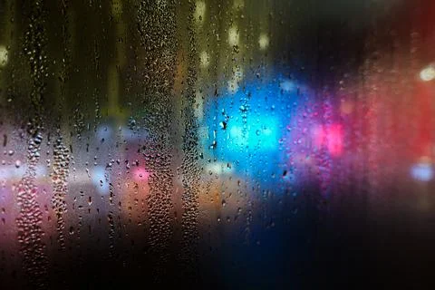 Rain drops on windshield glass window with road light bokeh, Colorful light.. Stock Photos