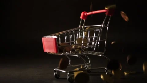 A rain of euro coin falls down on a mini shopping cart over a dark table Stock-Footage 160556997