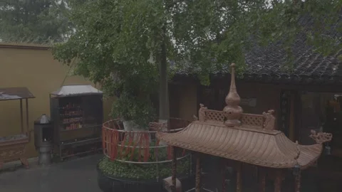 Rain Falling on Ancient Asian Buddhist Temple Courtyard with Red Prayer Ribbons Stock Footage 339370004