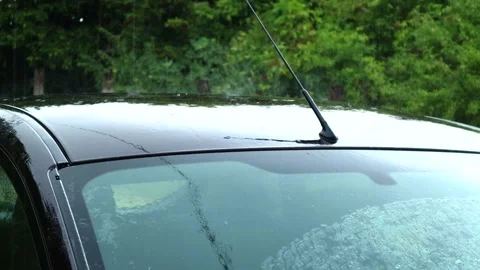 Rain falling and bouncing off the roof of the car during a strong summer Stock Footage 203712140