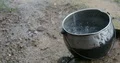 Rain falling and dropping in a metal pot on muddy bottom 4k or 4k+ Resolution