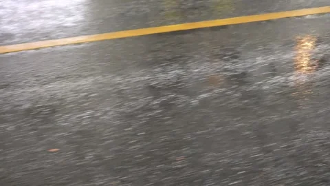 Rain falling on asphalt road with yellow stripes Stockbeeldmateriaal 311403223