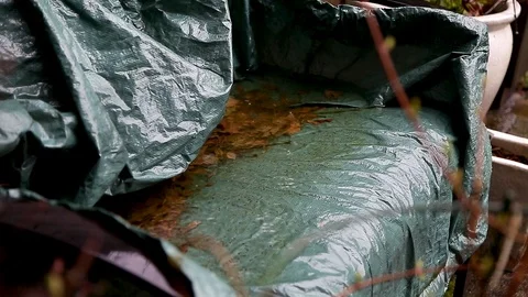 Rain falling on a bench with leaves on it. Stock Footage 96476379