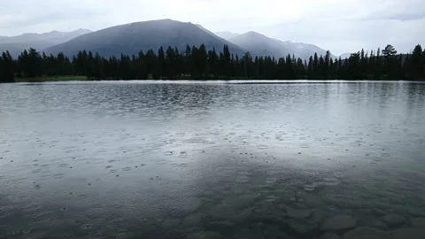 Rain falling into a calm mountain lake  Stock Footage 139286073