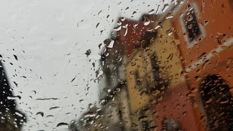 Rain falling on car glass, blurred houses background Stock Footage 106074227