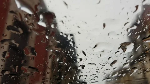 Rain falling on car glass, blurred houses background Stock Footage 106074315