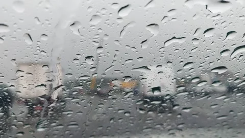 Rain falling on a car window during a busy day in the city with blurred images o Stock-Footage 327181124