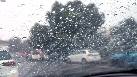 Rain falling on car windshield. Inside a car at heavy rain storm. Slow motion Video stock 221036901