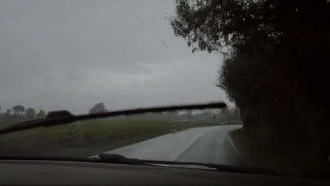 Rain falling on car windshield. small road in a rainy day. Slow motion 4K 库存影片 259174742