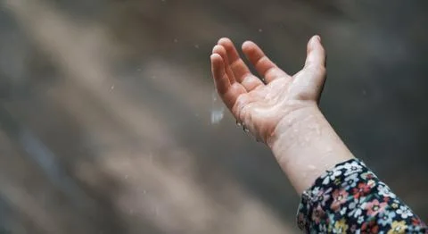 Rain falling in child hands outdoor Stock Photos
