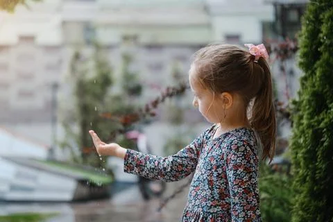Rain falling in child hands outdoor Stock Photos