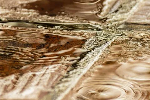 Rain falling on a clay tile floor forming puddles on it, close-up view captur Stock Photos
