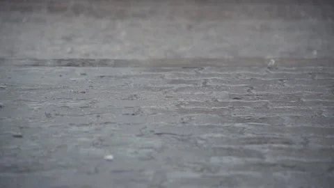 Rain falling down on a concrete floor and a flooded street on the back Stock Footage 104924877