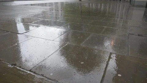 Rain falling down on the sidewalk. Video stock 107947447