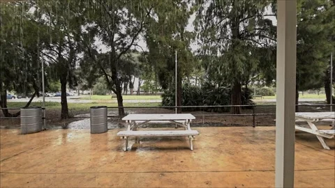 Rain falling on empty picnic table in park Stock Footage 305990767