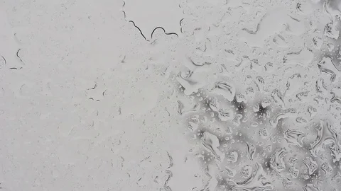 Rain falling on glass during rain storm, close up. Stock Footage 74539010