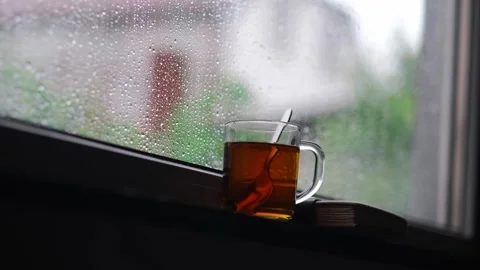 Rain falling on the glass window, flowing raindrops, the comfortable sound of Stock Footage 282083298