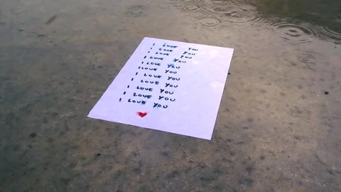 Rain Falling on a I Love You Letter in Slow Motion Outdoors Stock Footage 338001693