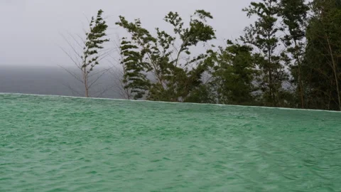 Rain Falling on Infinity Pool Overlooking Stormy Sea Video stock 347984222