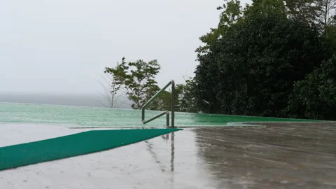 Rain Falling on Infinity Pool Overlooking Stormy Sea Video stock 347984386