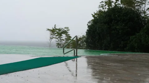 Rain Falling on Infinity Pool Overlooking Stormy Sea Video stock 347996366