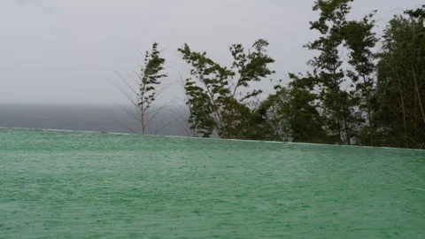 Rain Falling on Infinity Pool Overlooking Stormy Sea Video stock 347996369