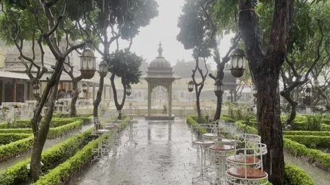 Rain falling in open heritage garden restaurant moody scene 库存影片 332920891