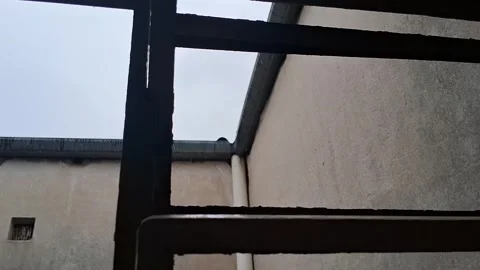 Rain falling outside a metal window frame in motion video footage Stock Footage 339505167