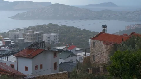 Rain falling over aegean coast, houses and distant island Stock Footage 322121139