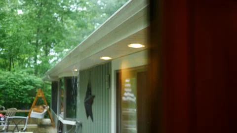 Rain Falling Over Full Gutter in Ranch Home During Storm Stock Photos