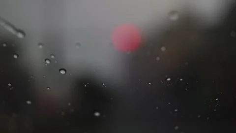 Rain falling over windshield of a car, beautiful bokeh Stock Footage 246433080