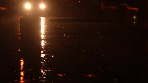 Rain Falling in Parking Lot With Car Headlights in Background Stock Footage 319509401