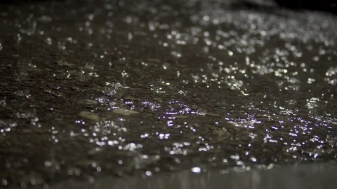 Rain falling on pavement asphalt surface at night, background loop Stock Footage 109538144